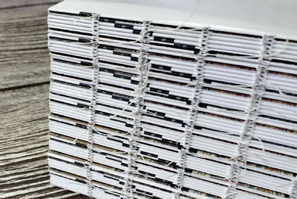 In Hoa Long thực hiện Kỹ thuật đóng keo gáy kết hợp may chỉ